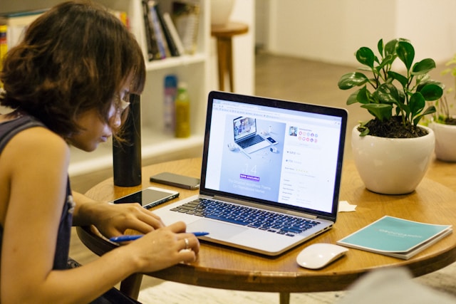 woman taking notes at a coffee table